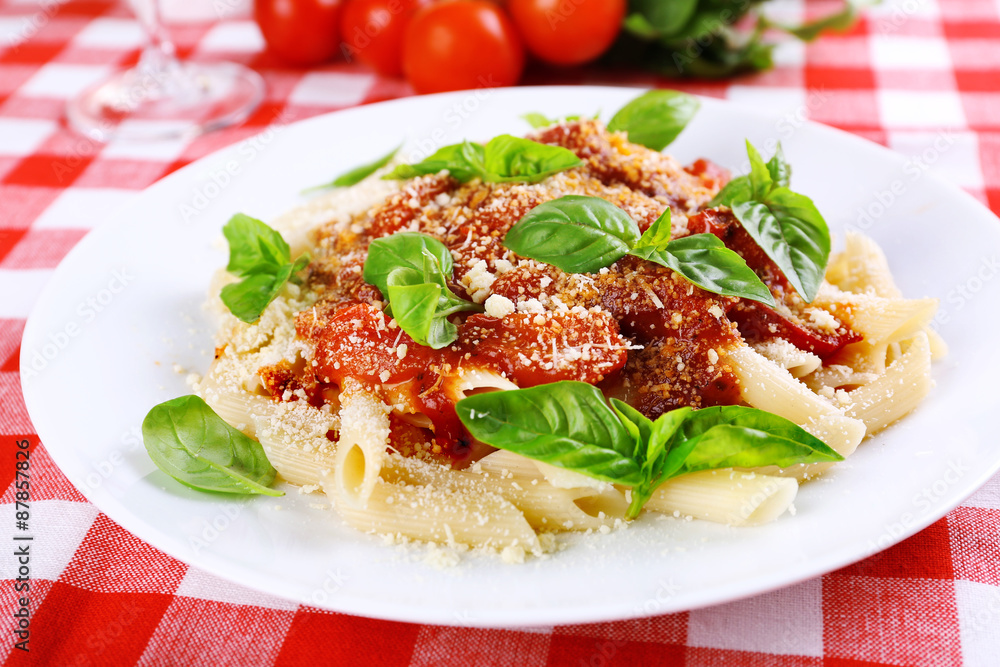 Pasta with tomato sauce and basil on table close up Pasta with tomato sauce and basil on table close up