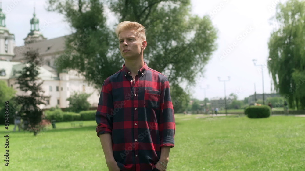 Pensive boy standing alone in the park and looking around
Pensive boy standing alone in the park and looking around