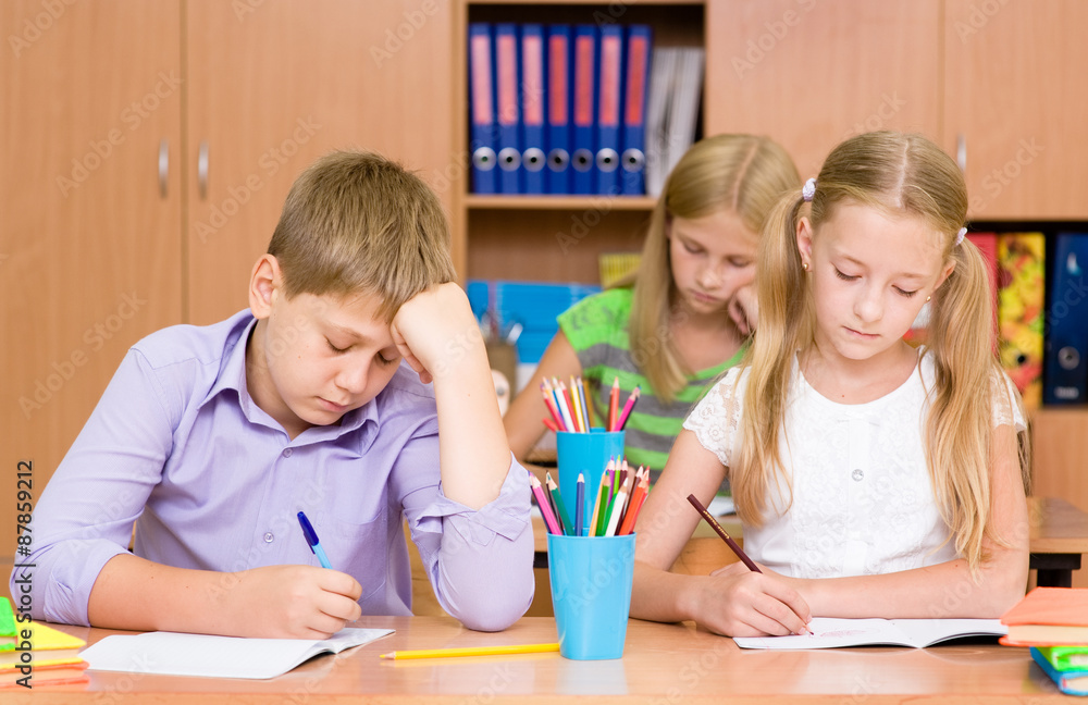 Fototapeta premium Group of elementary school pupils takes the test in class