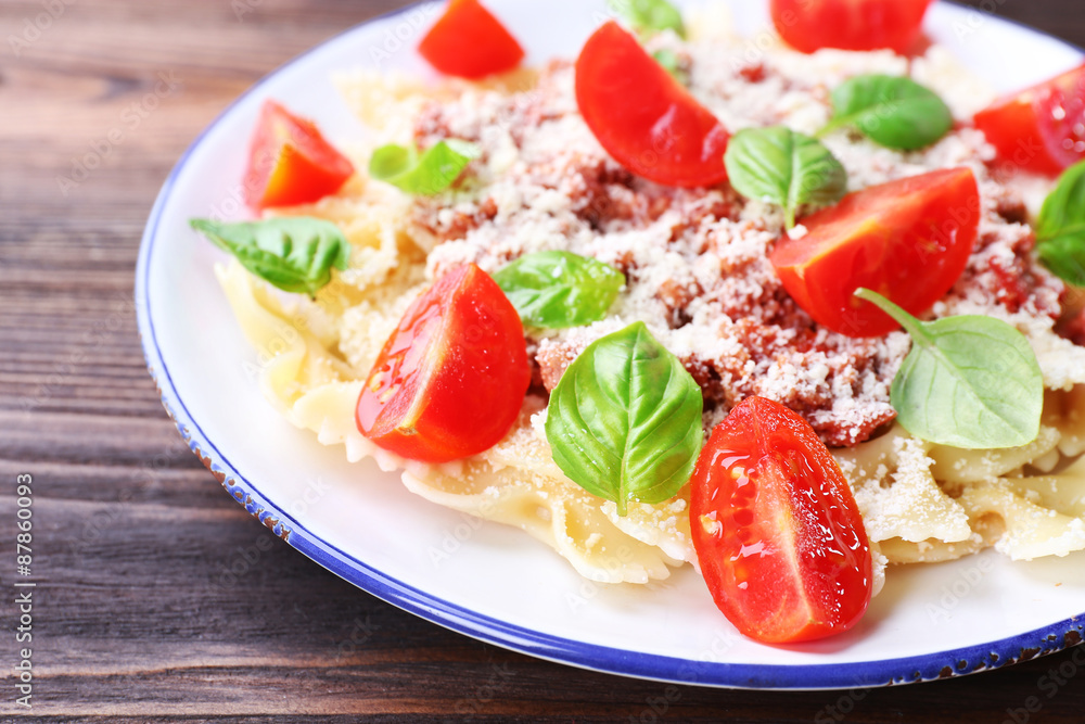Pasta bolognese with cherry tomatoes in white plate on wooden table, closeup Pasta bolognese with cherry tomatoes in white plate on wooden table, closeup