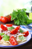 Pasta bolognese with cherry tomatoes in white plate on wooden table, closeup