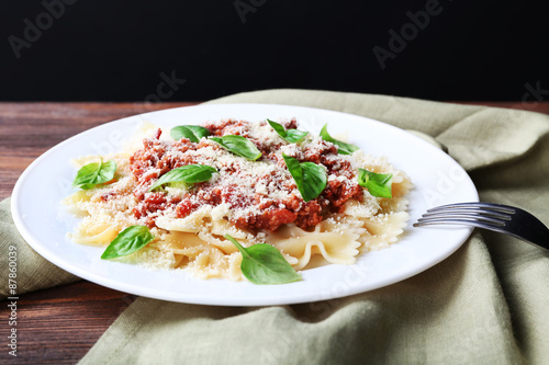 Pasta bolognese on wooden table on dark background