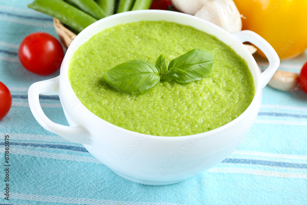 Tasty peas soup and vegetables on table close up Tasty peas soup and vegetables on table close up