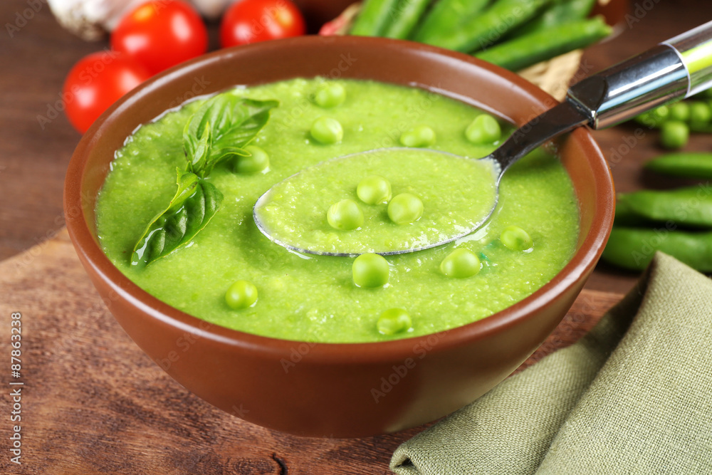 Tasty peas soup and cherry tomatoes on table close up Tasty peas soup and cherry tomatoes on table close up