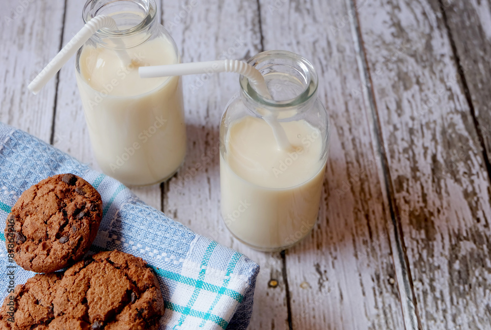 Horizontal shot of some chocolate cookies and two glasses of milk on a rustic table
Horizontal shot of some chocolate cookies and two glasses of milk on a rustic table
