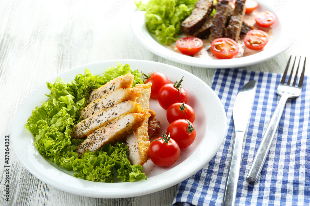 Slices of chicken fillet with spices and cherry tomato on table close up Slices of chicken fillet with spices and cherry tomato on table close up