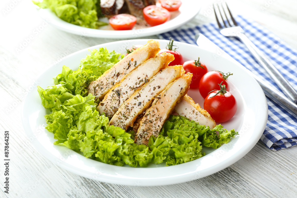 Slices of chicken fillet with spices and cherry tomato on table close up Slices of chicken fillet with spices and cherry tomato on table close up