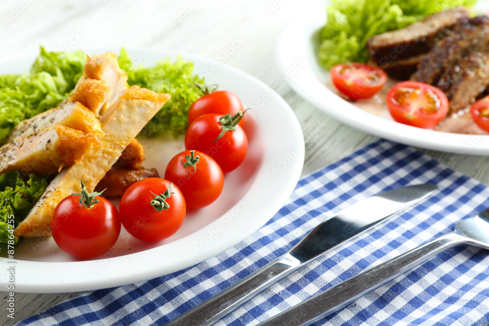 Slices of chicken fillet with spices and cherry tomato on table close up Slices of chicken fillet with spices and cherry tomato on table close up