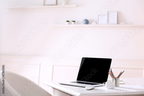 Workplace with laptop in room © Africa Studio