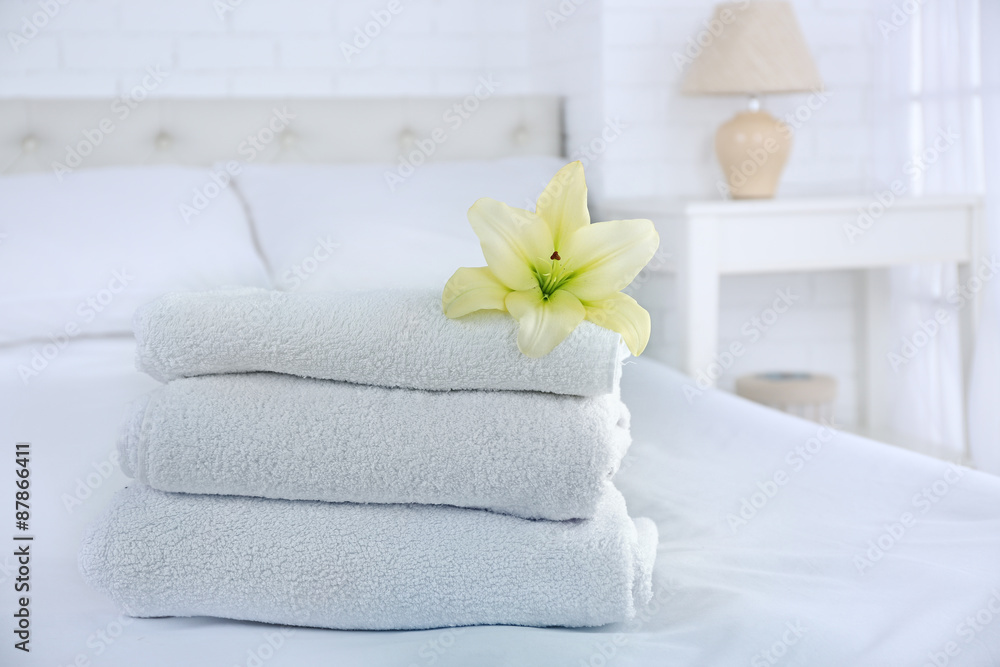 Freshly laundered fluffy towels in bedroom interior Freshly laundered fluffy towels in bedroom interior