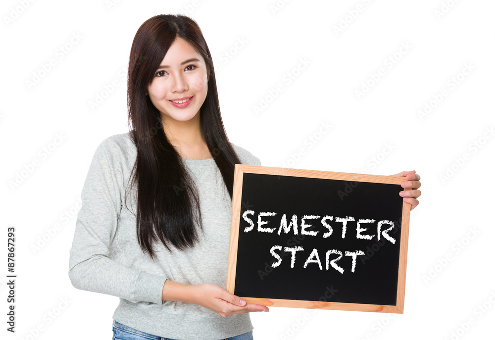 Young woman hold with chalkboard showing semester start on board Young woman hold with chalkboard showing semester start on board