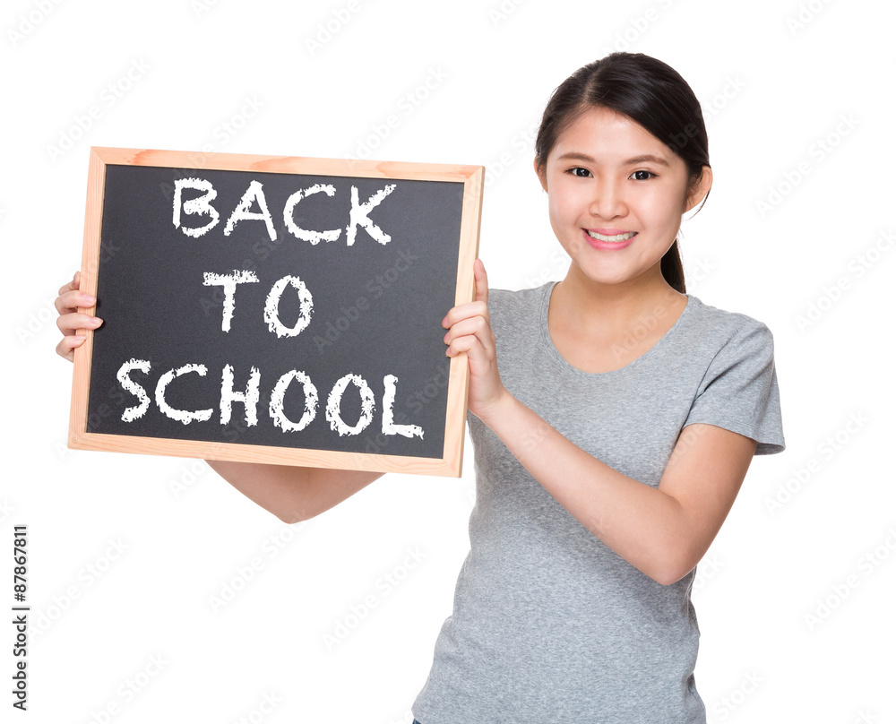 Young student hold with black board showing phrase of back to sc Young student hold with black board showing phrase of back to sc