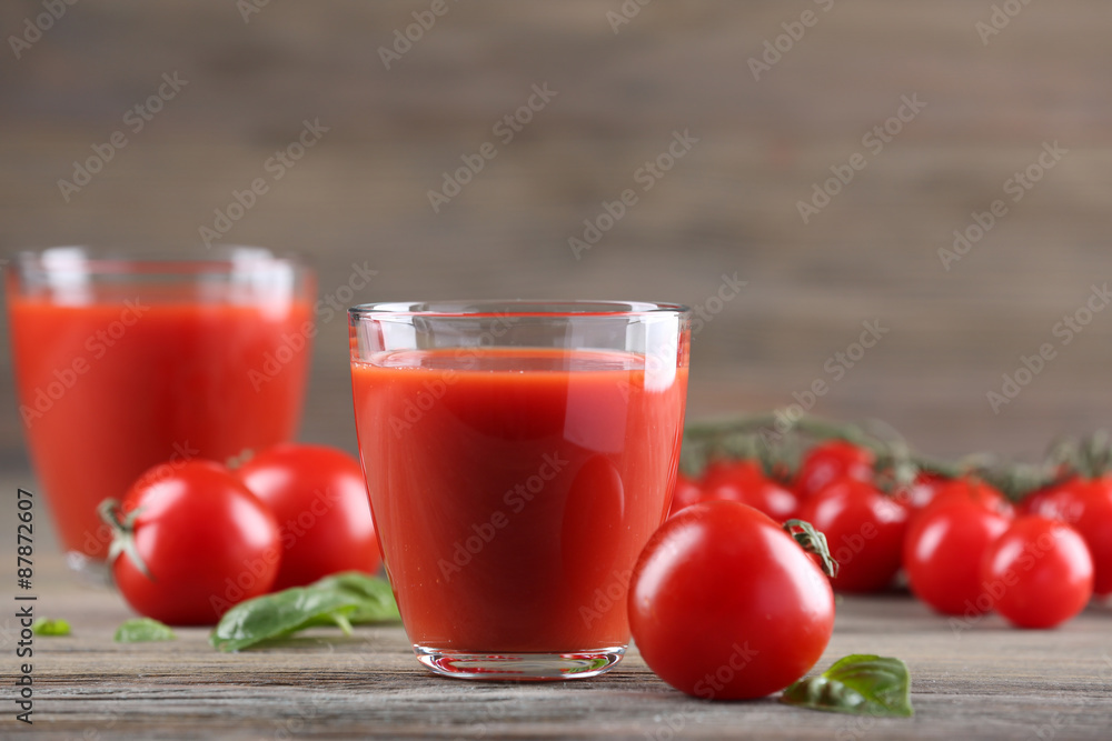Glasses of tomato juice with vegetables on wooden table close up Glasses of tomato juice with vegetables on wooden table close up