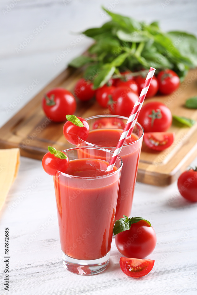 Glasses of tomato juice with vegetables on wooden table close up Glasses of tomato juice with vegetables on wooden table close up