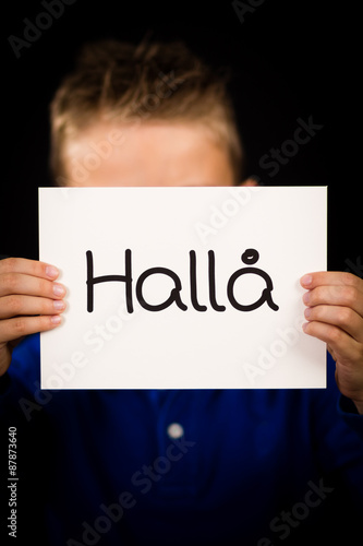 Child holding sign with Swedish word Halla - Hello
