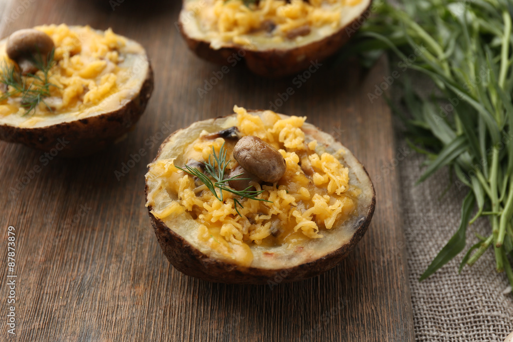 Baked potatoes with cheese and mushrooms on table close up