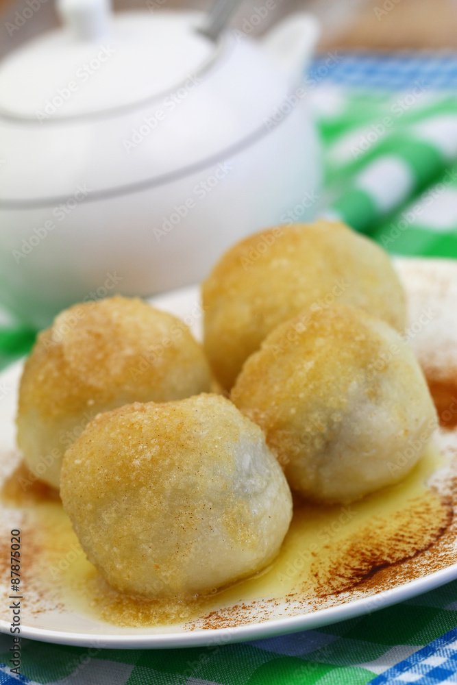 Sweet dumplings sprinkled with sugar and cinnamon, closeup
Sweet dumplings sprinkled with sugar and cinnamon, closeup
