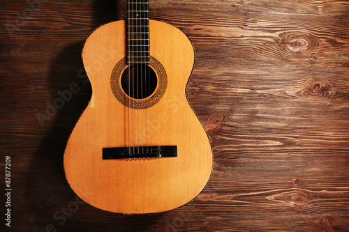 Acoustic guitar on wooden background