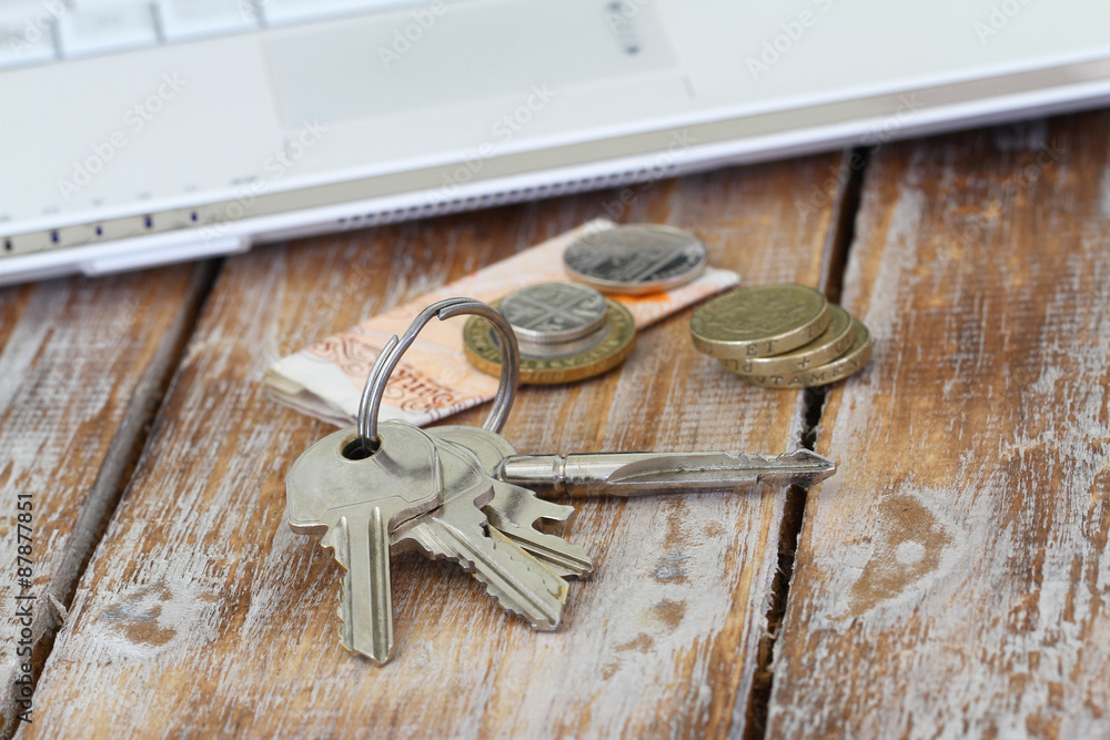 Bunch of keys on rustic surface and some change in British pounds