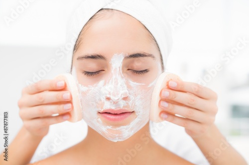 Hands cleaning woman face with sponge