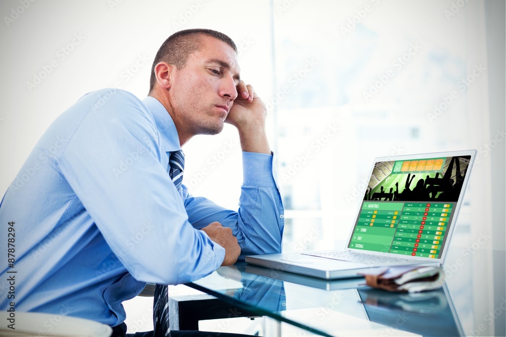 Fototapeta premium Composite image of tired businessman looking at his laptop