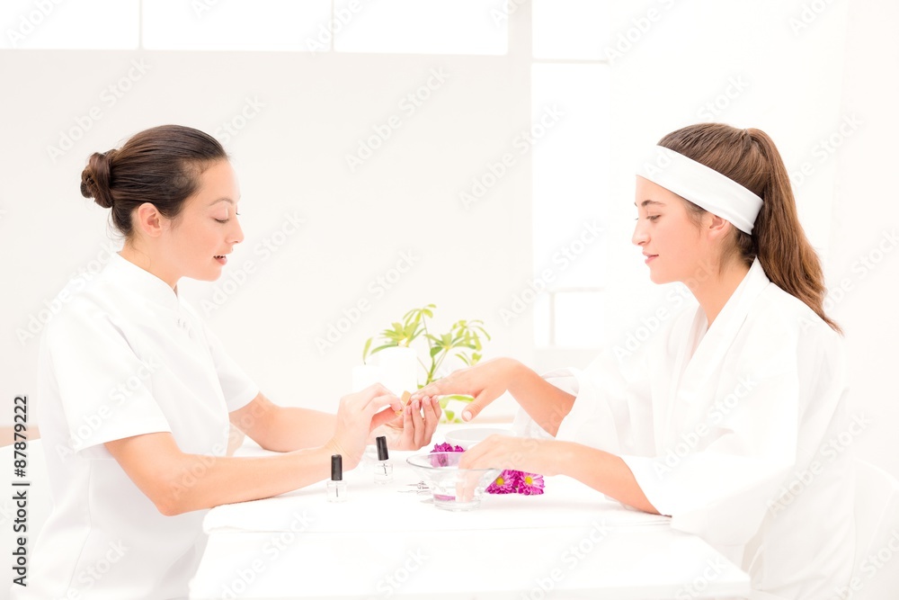 Obraz premium Beautician filing female clients nails at spa beauty salon
