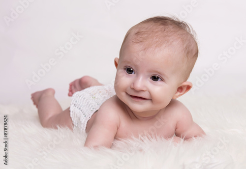 young baby lying on blanket and smiling