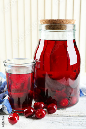 Sweet homemade cherry compote on table, on light background