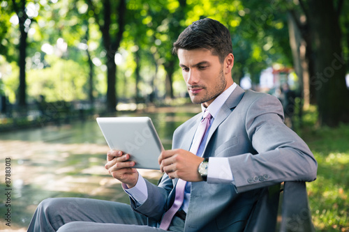 Businessman using tablet computer outdoors