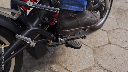 Biker starts motorbike.
