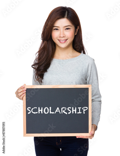 School girl hold with chalkboard and showing a word scholarship