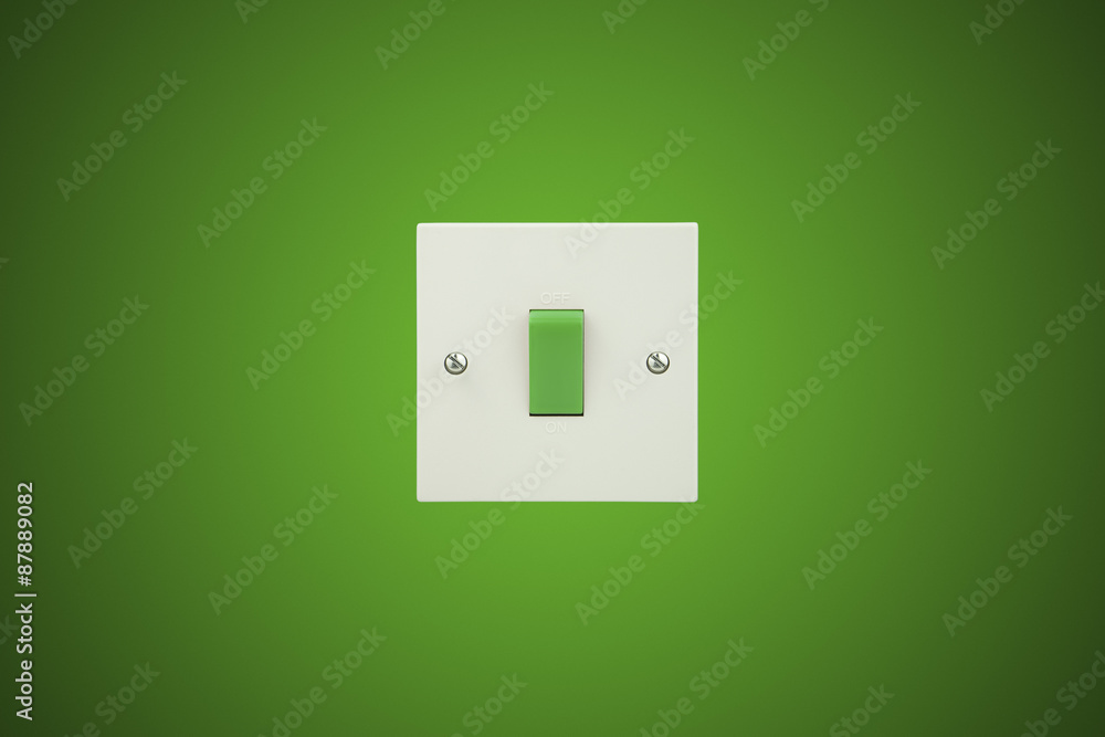 Green Switch on a white socket and a green background wall Green Switch on a white socket and a green background wall