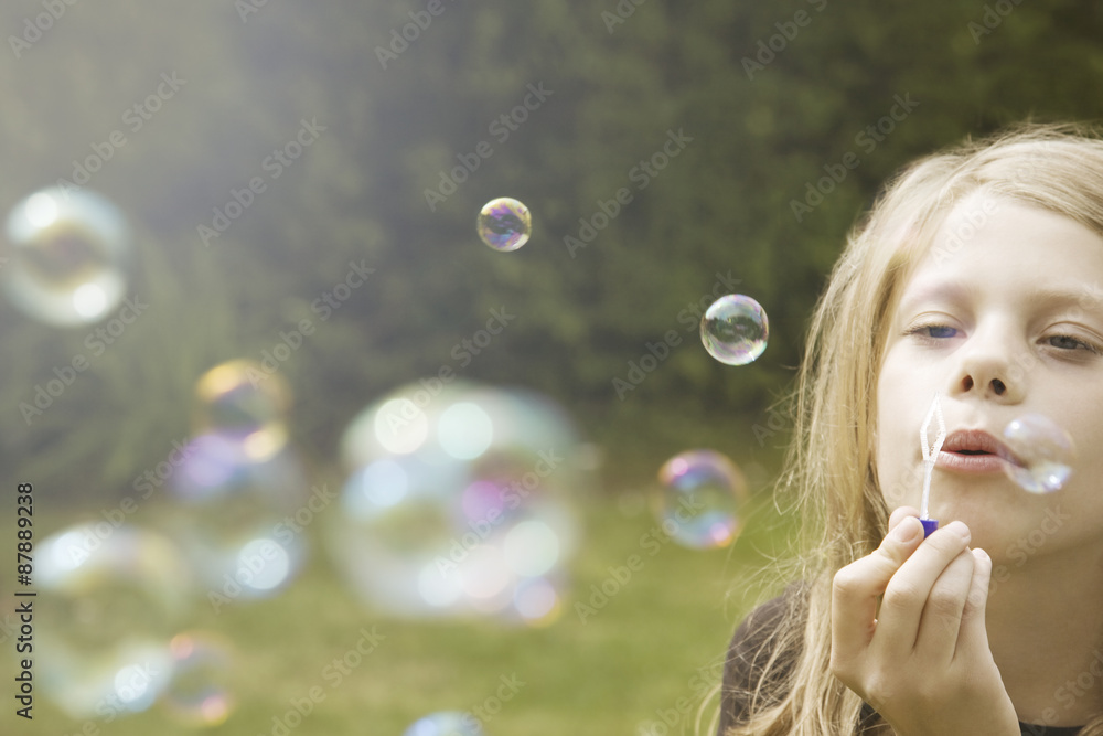 Young girl blowing bubbles