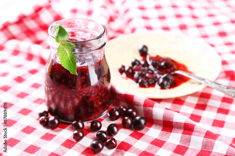 Jar of gooseberry jam on wooden table close-up Jar of gooseberry jam on wooden table close-up