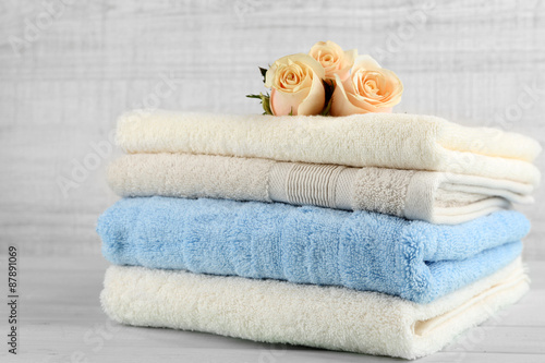 Stack of colorful towels on light wooden background © Africa Studio