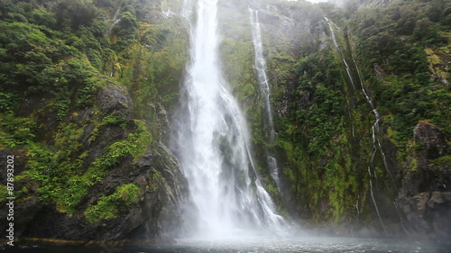 Close approach to waterfall by boat, Milford Sound Fjord. South Island, New Zealand. photo