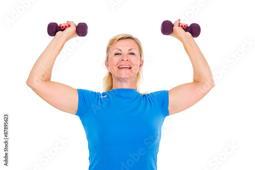 Happy and smile old senior woman in sport outfit in gym working out with dumbbells in hands, isolated on white background, Positive human emotions