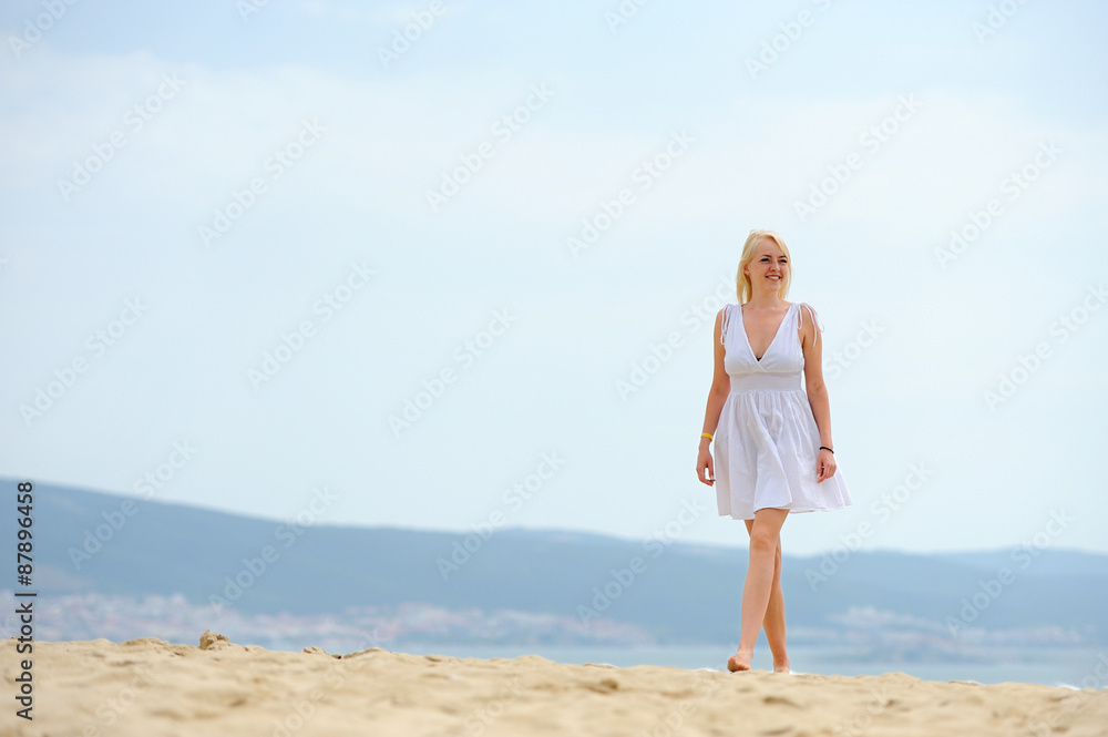Woman on the beach in white dress
