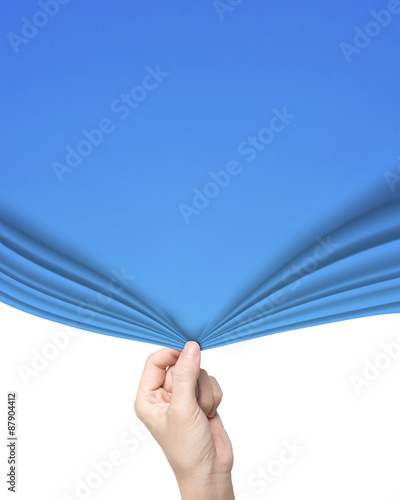 Woman hand pulling open blue curtain covering blank white