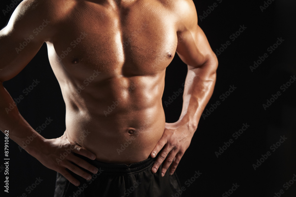 Bare chested male body builder with hands on hips, crop