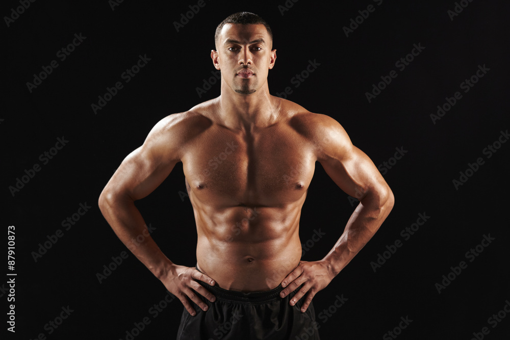 Bare chested male body builder with hands on hips