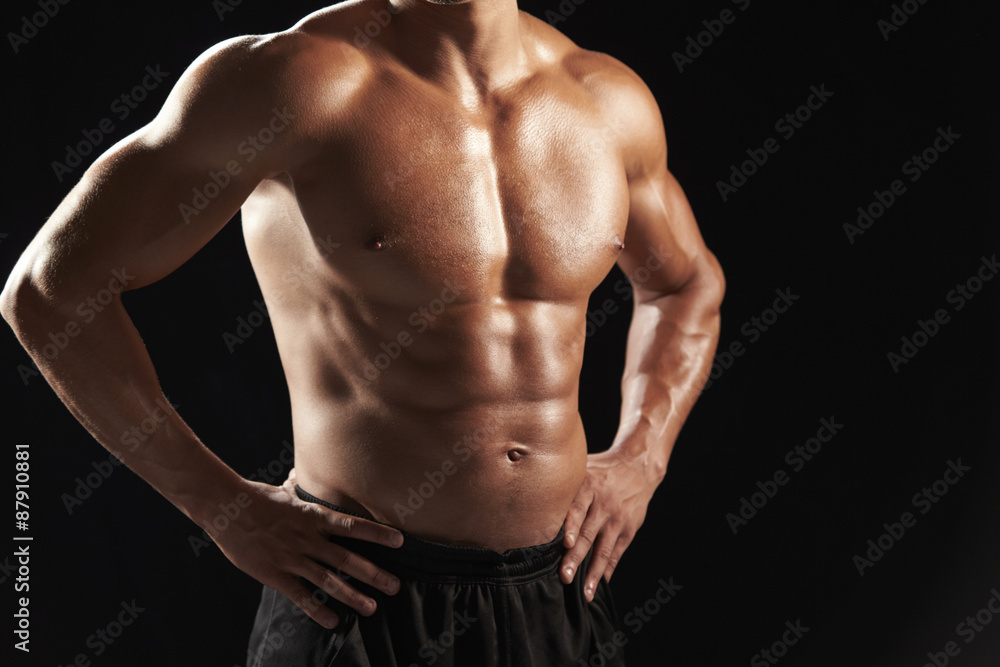 Bare chested male body builder with hands on hips, crop