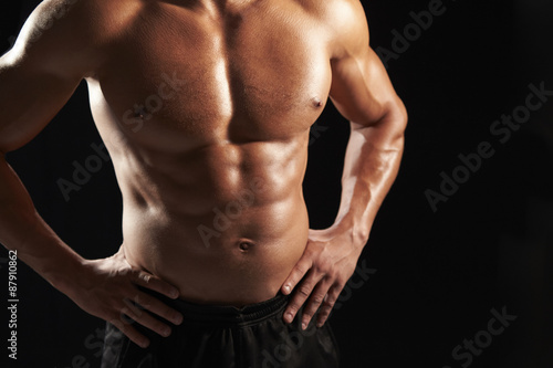 Bare chested male body builder with hands on hips  crop