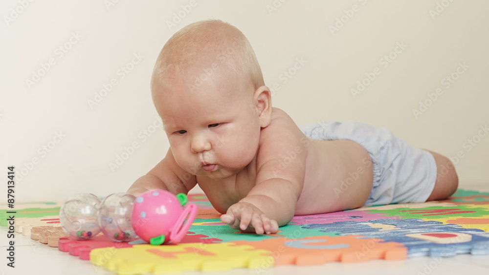 Baby boy plays with toy on light background Baby boy plays with toy on light background