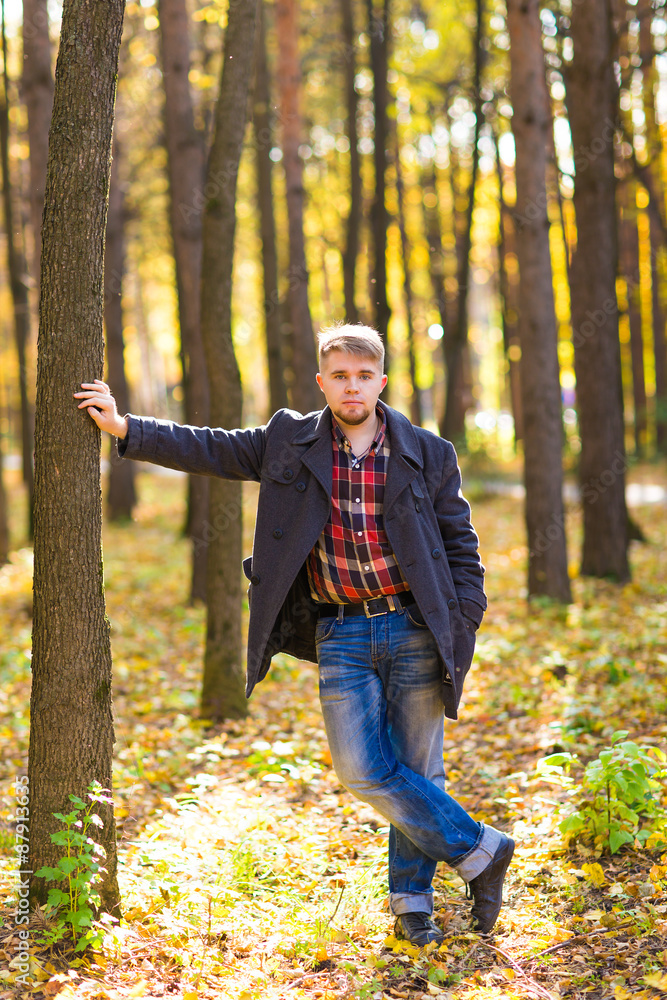 man wearing a coat in the autumn park man wearing a coat in the autumn park