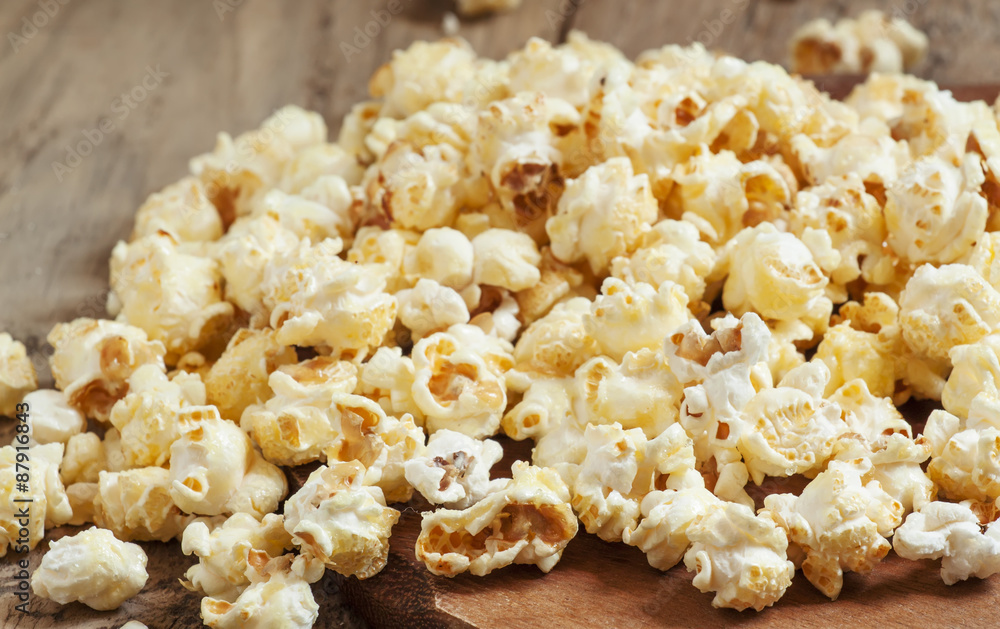 Sweet caramel popcorn in a wooden bowl, selective focus Sweet caramel popcorn in a wooden bowl, selective focus