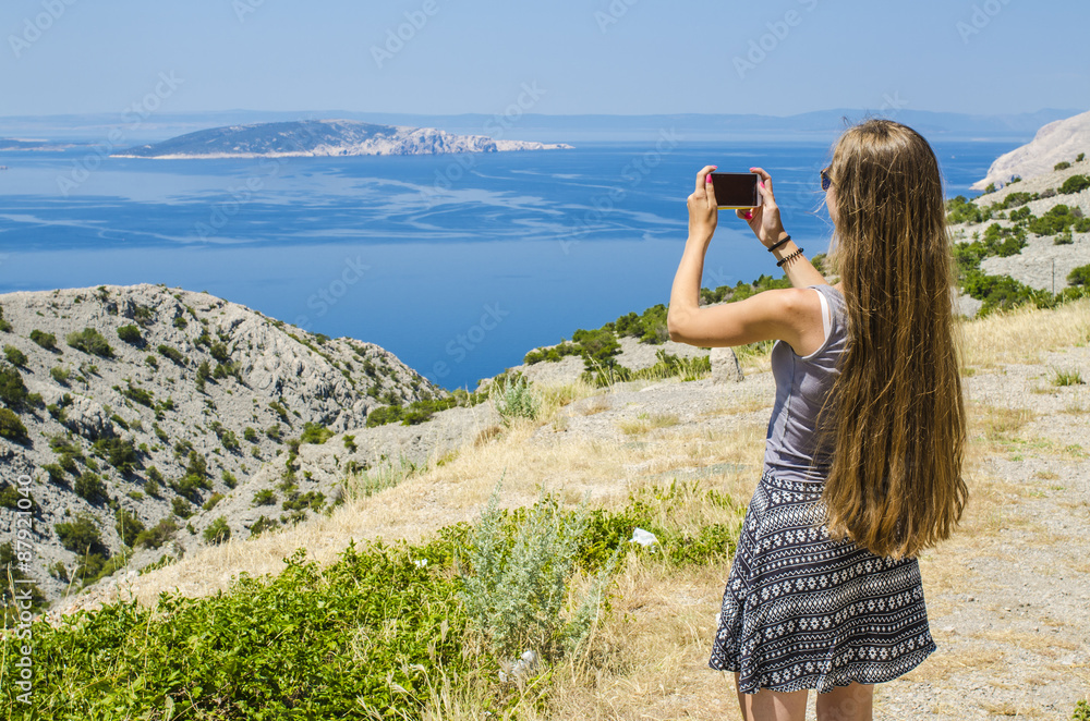 Young attractive girl taking photo of tropical landscape Young attractive girl taking photo of tropical landscape