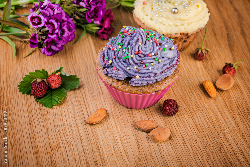 delicious cupcakes  decorated with berries and wild flowers