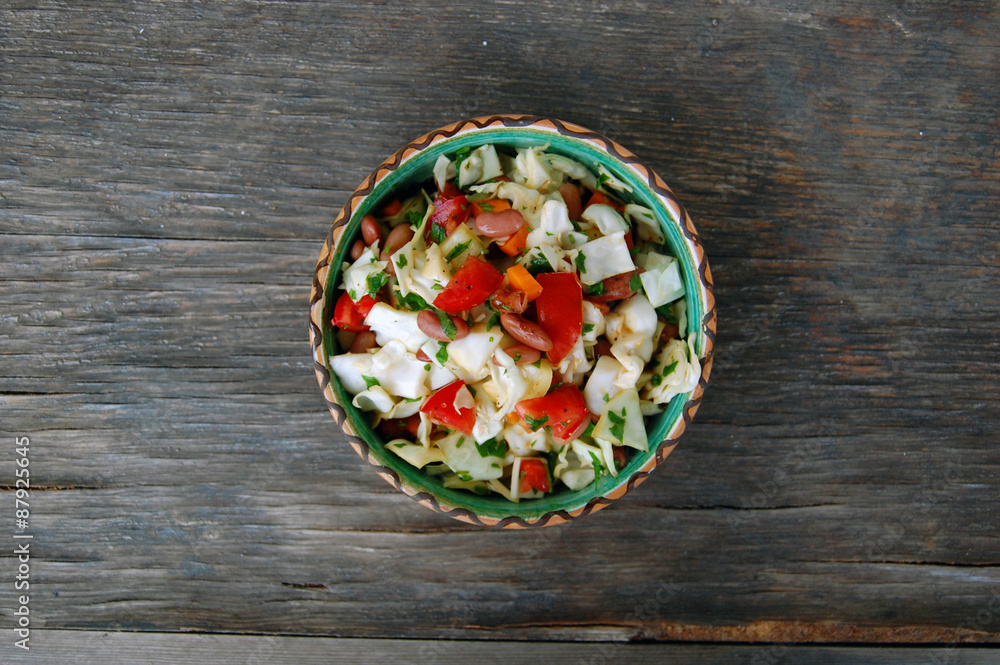 fresh tomato and cabbage salad with parsley in ceramic bowl on rustic wooden table fresh tomato and cabbage salad with parsley in ceramic bowl on rustic wooden table