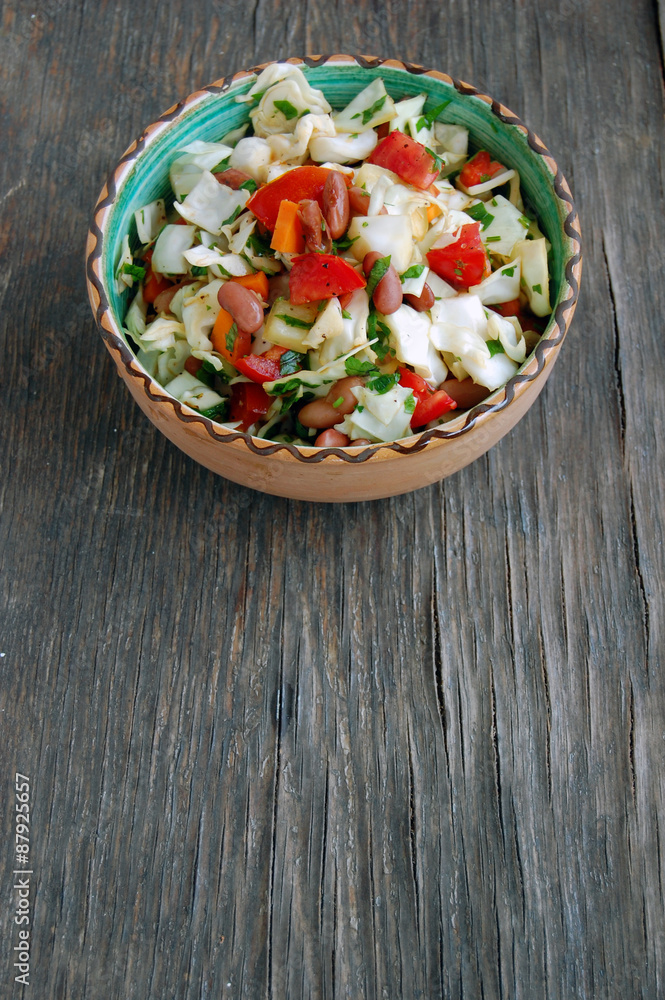 fresh tomato and cabbage salad with parsley in ceramic bowl on rustic wooden table fresh tomato and cabbage salad with parsley in ceramic bowl on rustic wooden table